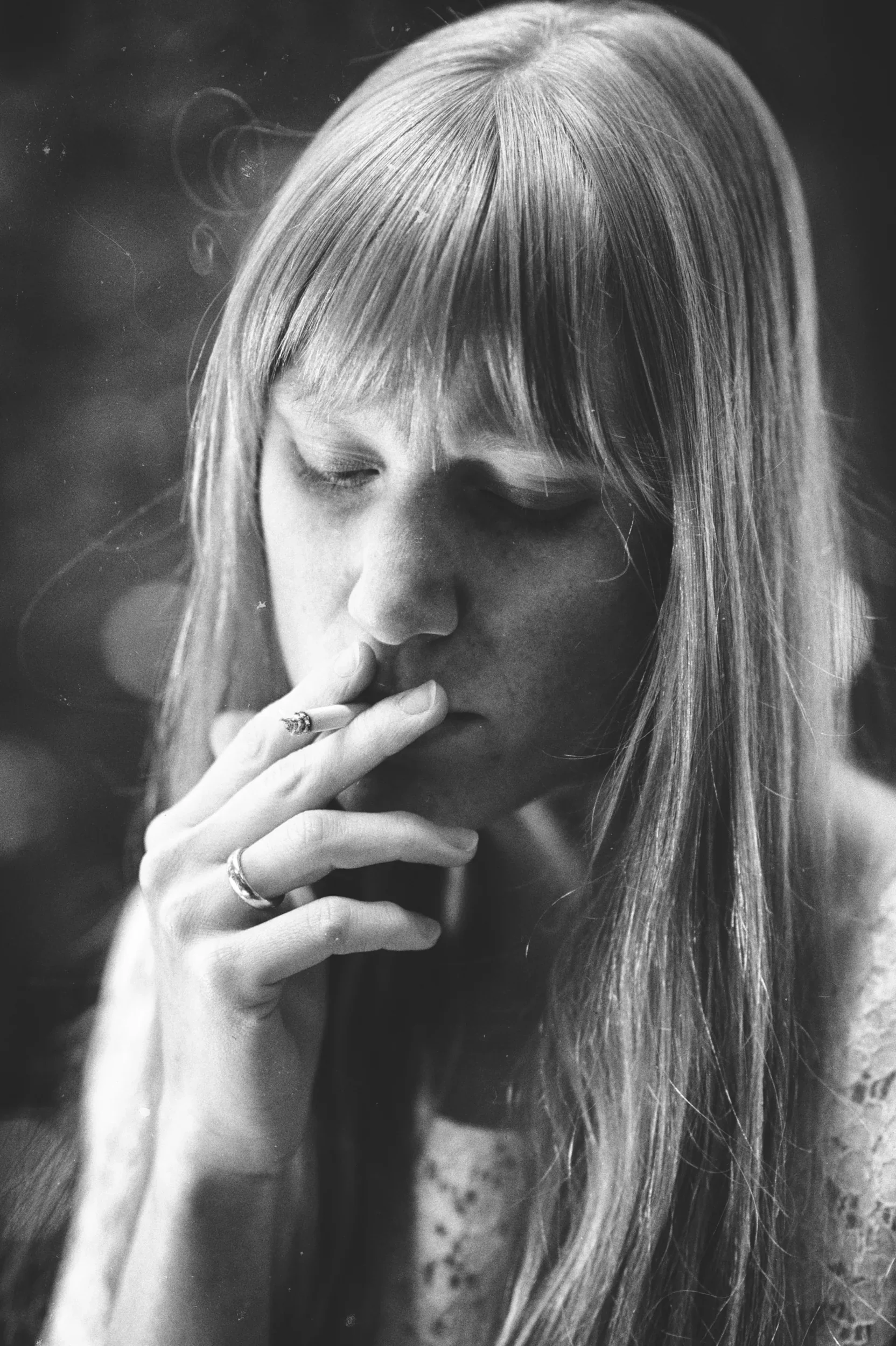 Atmospheric black and white close-up of a woman smoking a cigarette.